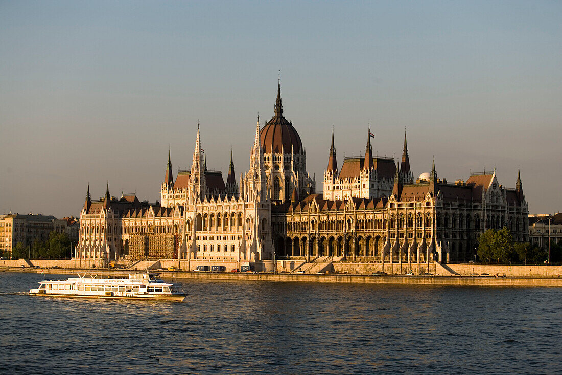 Parliament and Danube river with boat, A leisure boat on the Danube river passing the Parliament, Pest, Budapest, Hungary