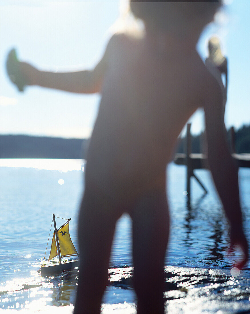 Little child playing on lake