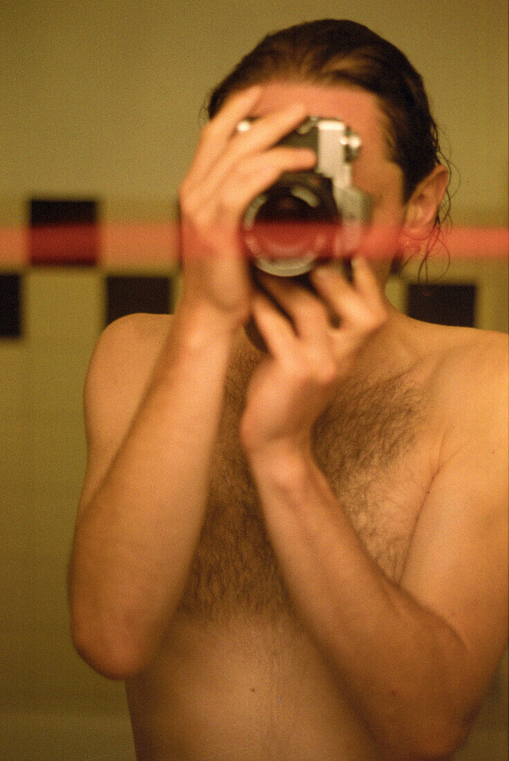 Mann fotografiert sich selbst im Spiegel, Badezimmer