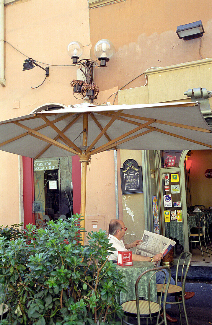 Senior liest Zeitung in Café, Rom, Italien