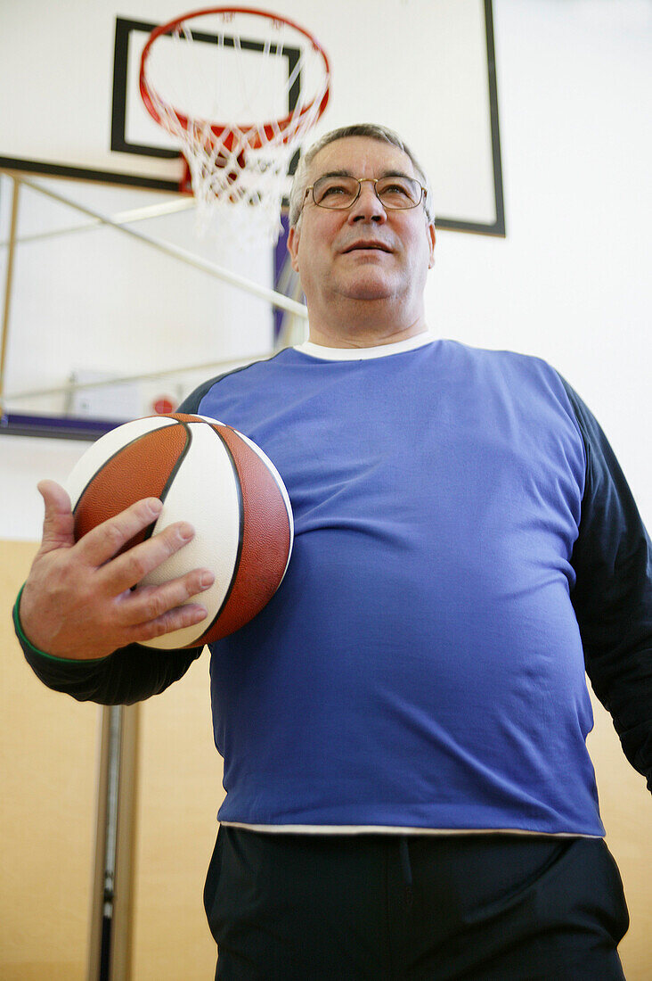 Mature man playing basketball