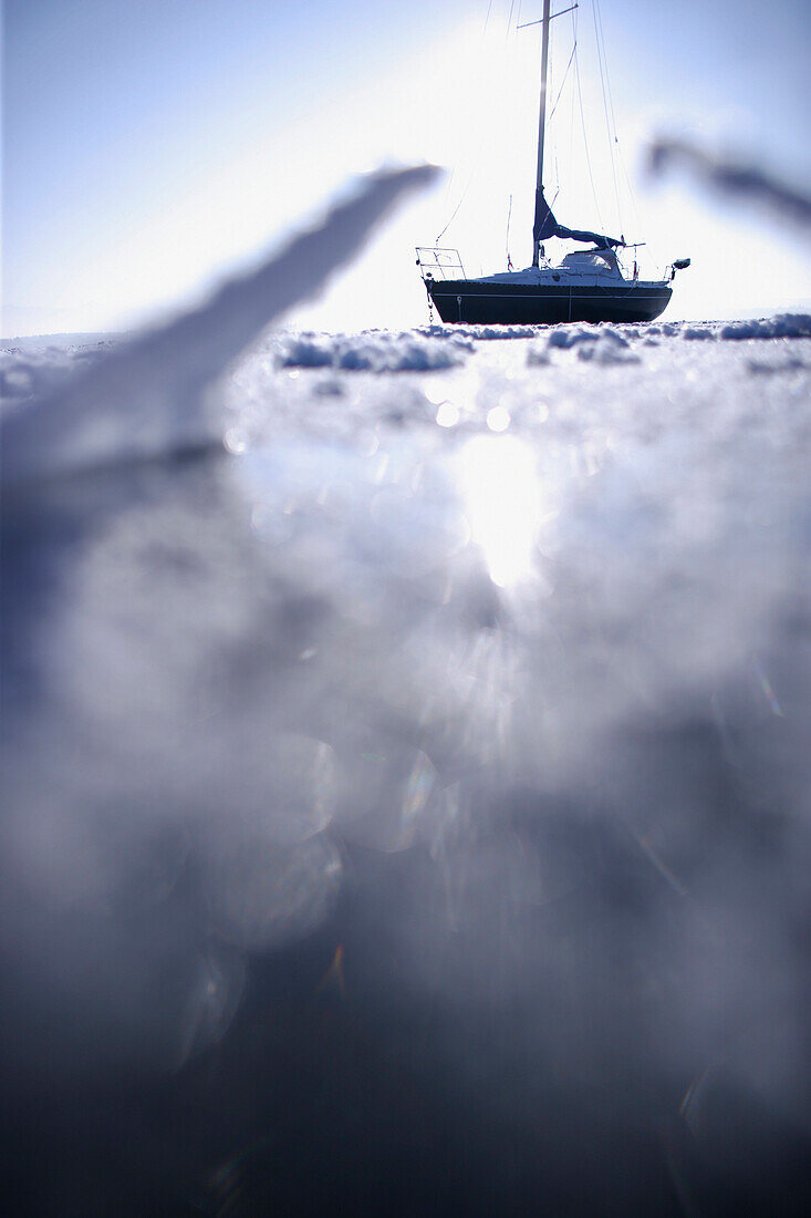 Segelboot im zugefrorenen See, Ambach, Starnberger See, Bayern, Deutschland