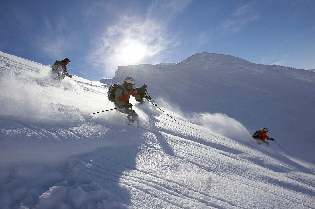 Four people skiing on powder snow, Nebelhorn, Oberstdorf, Bavaria, Germany