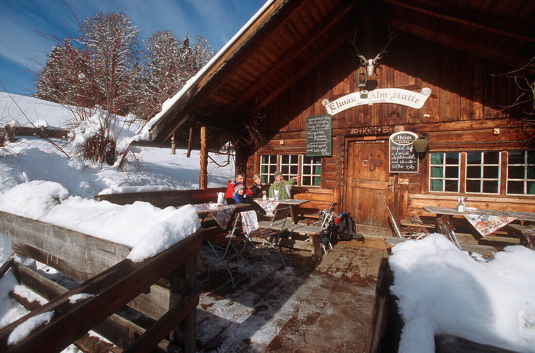 People sitting on terrace of Elmauer ski lodge, Elmau, Germany