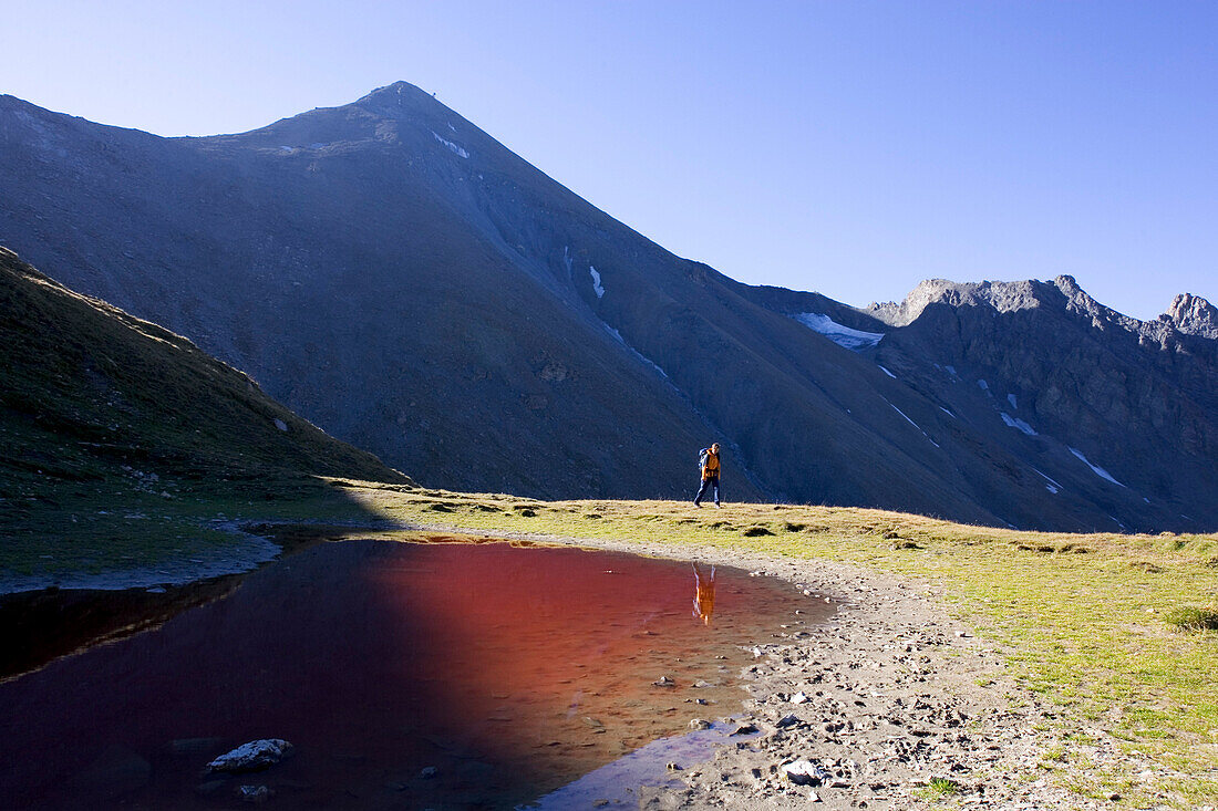 Junge Frau wandert am Roten Seeli vorbei, Samnaun, Unterengadin, Graubünden, Schweiz