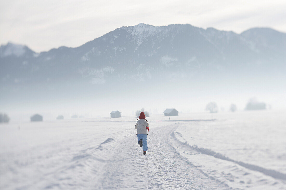 Mädchen 5-6 Jahre, rennt im Schnee