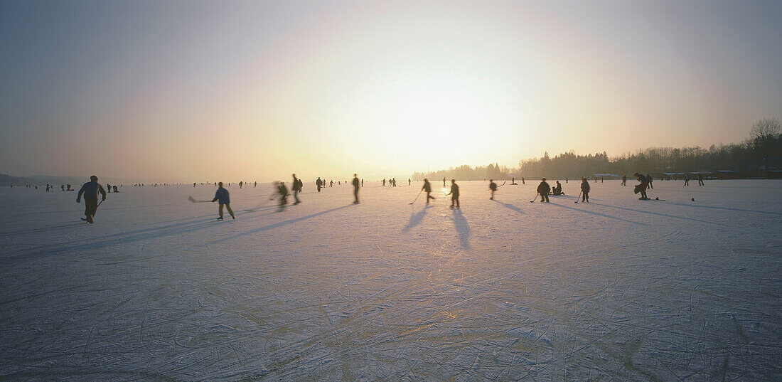 People ice skating on frozen lake, Upper Bavaria, Germany