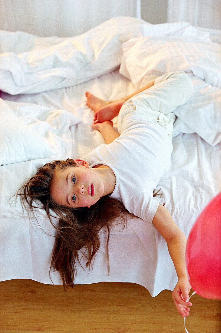 Girl holding red balloons