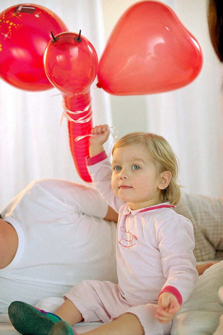 Kleines Mädchen mit roten Luftballons