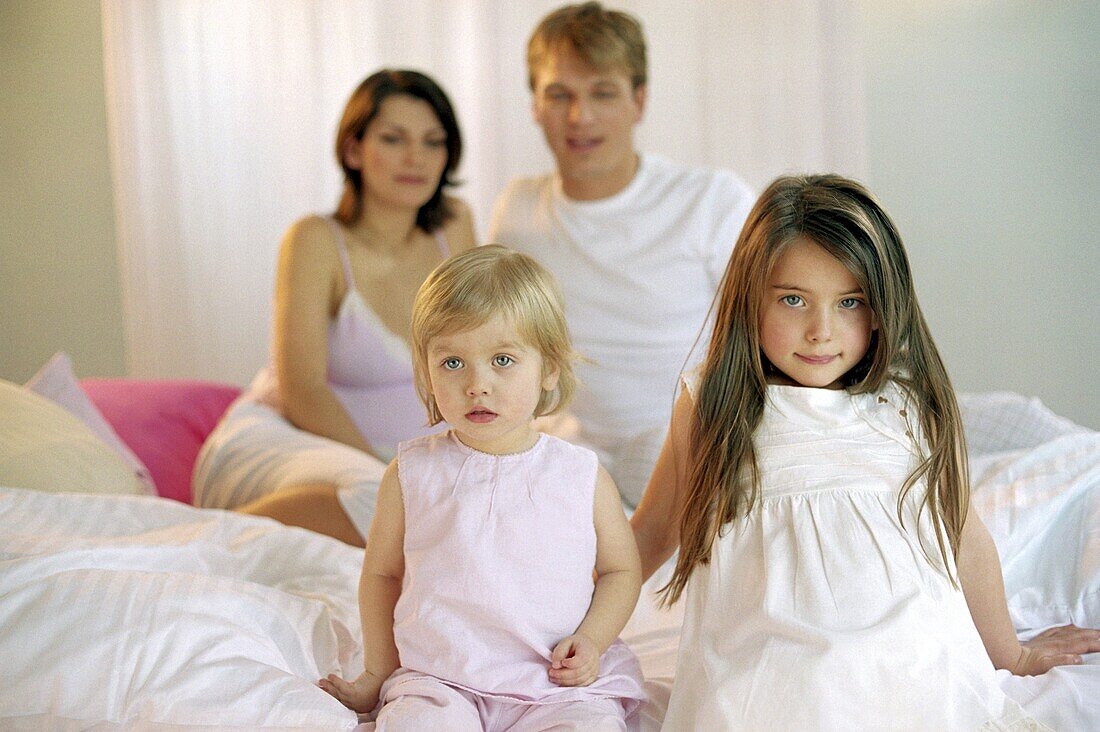 Young family sitting on the bed, portrait