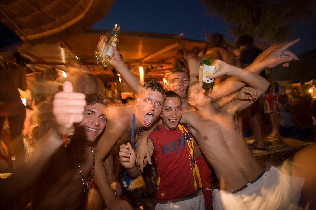 Men amusing during the Full Moon Party of the Tropicana Club, Paradise Beach, Mykonos, Greece