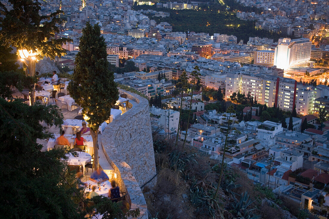 View from the Lykavittos Hill over a restaurant to the ocean of houses of the town at night, Athens, Athens-Piraeus, Greece
