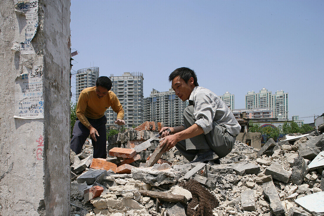 Abriss, demolition, Shanghai,migrant construction worker clearing bricks, Wanderarbeiter reinigen Ziegelsteine, redevelopment area, Abrissgebiet, Leben zwischen Ruinen, Living amongst ruins, encroaching new highrise, neue Hochhäuser anstelle alter Wohnstr