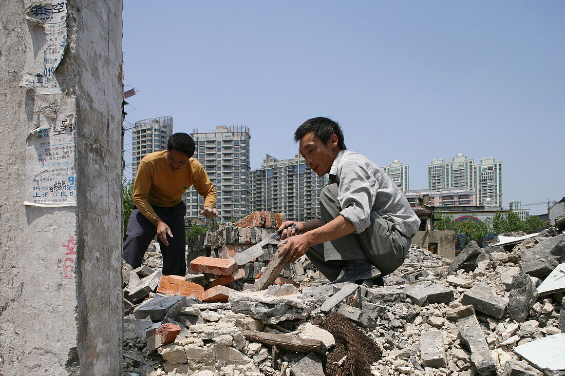 demolition,migrant construction worker clearing bricks, redevelopment area, Living amongst ruins, encroaching new highrise