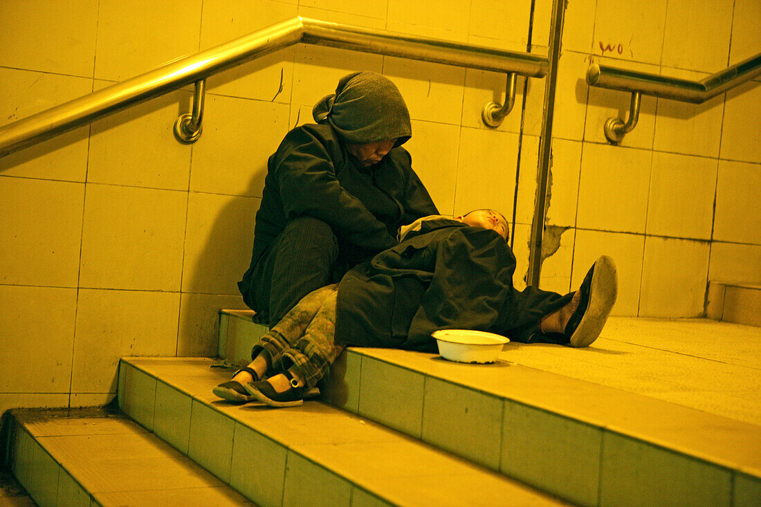 Beggar with young child, Metro