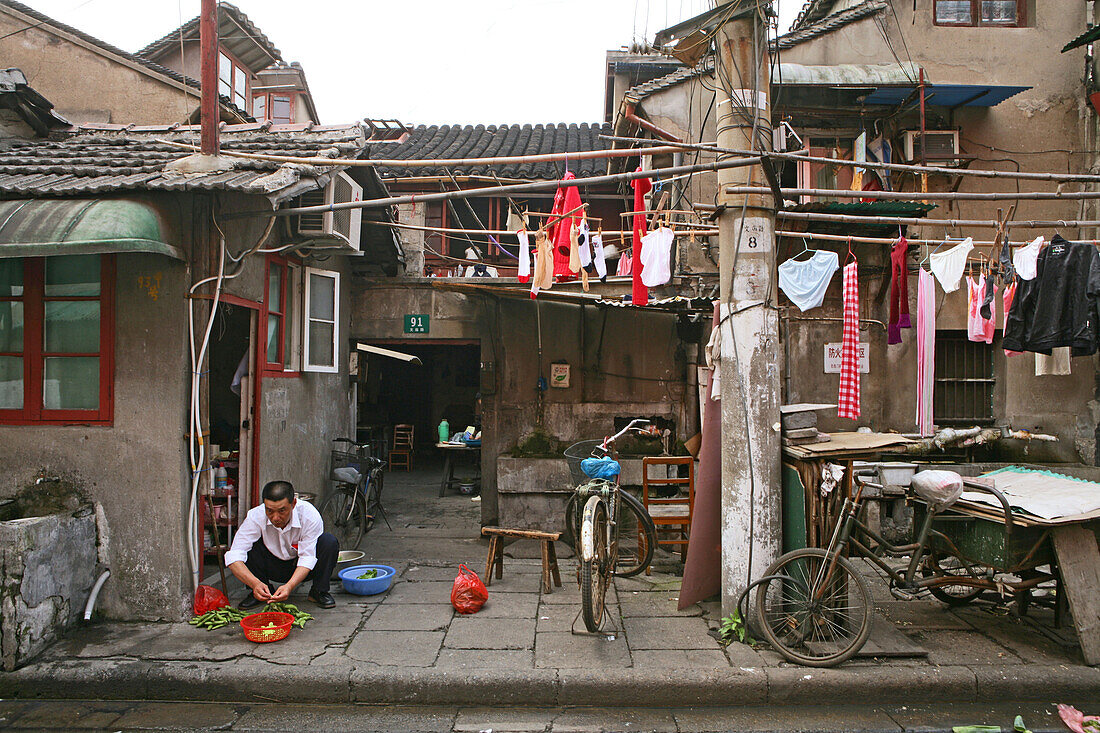 old town, Lao Xi Men,Mann wäscht sein Gemüse auf, man cleaning vegetable in the streets, household chores of a traditional house, Gehweg als Lebensraum, chinese house fronts onto the street, laundry, beengtes Wohnen, close living