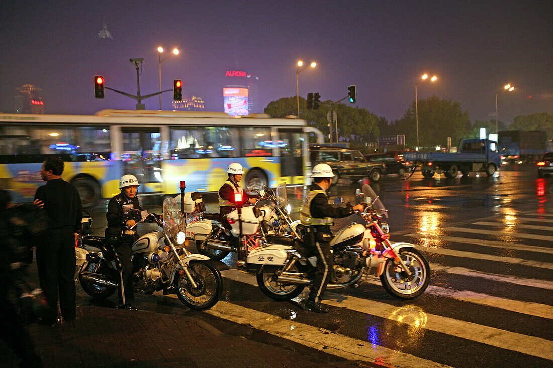 Traffic Shanghai,motorbike patrol, Polizei, police, Bund, junction, Nanjing Road, Blaulicht, rain