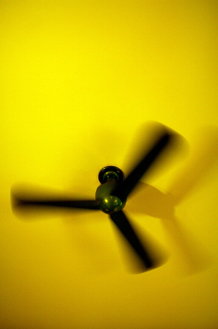 Schwarzer Ventilator an gelber Decke