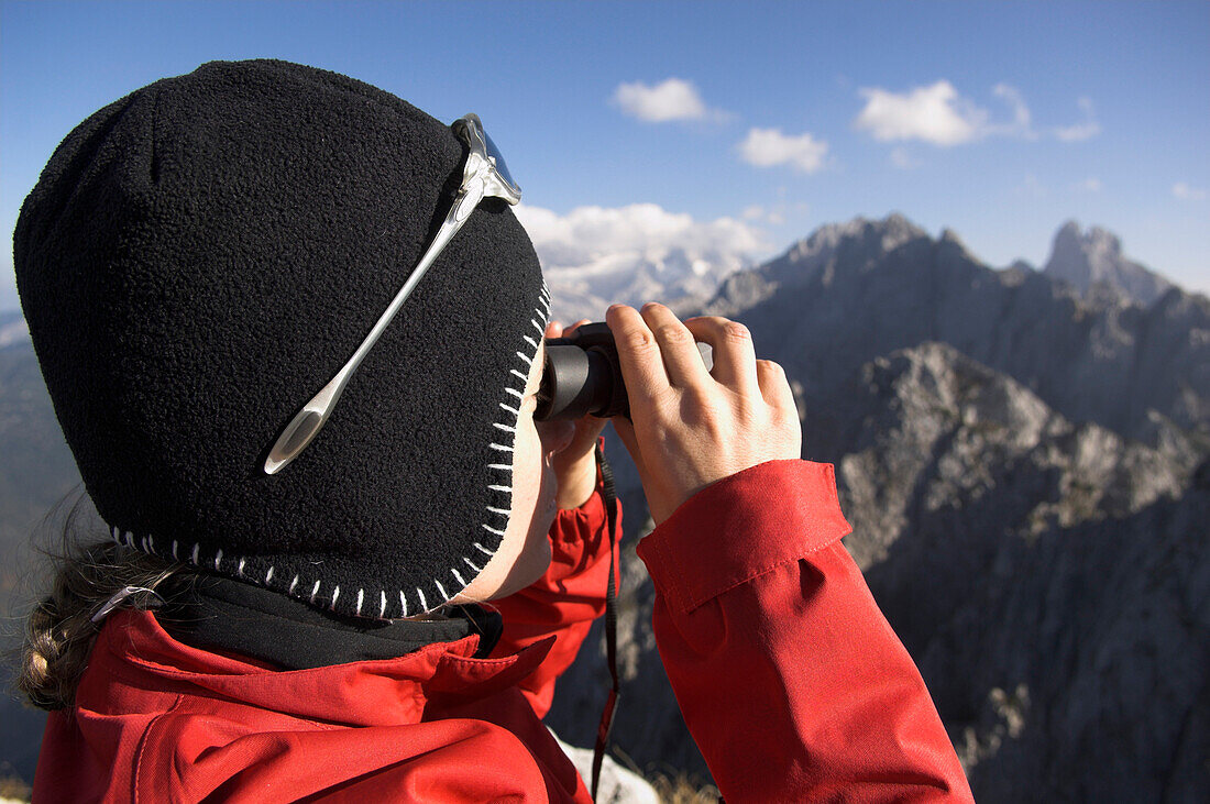 Bergsteigerin blickt durchs Fernglas, Dachsteingebirge, Österreich