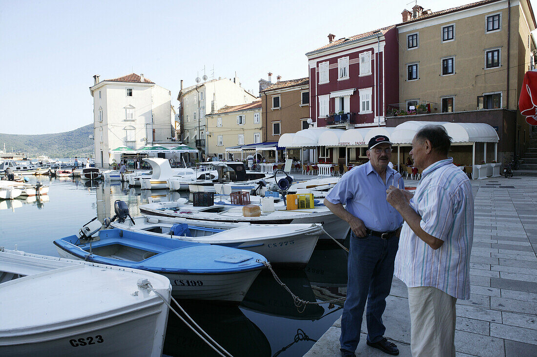 Zwei Männer reden im Hafenviertel, Hafen von Cres, Insel Cres, Kroatien