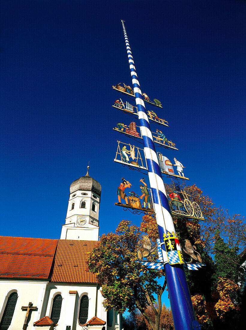 Low angle view of maypole and country church, Erling, Upper Bavaria, Germany