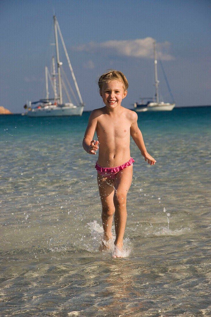 Kind läuft im Wasser, Cala Brandinchi, Sardinien, Italien