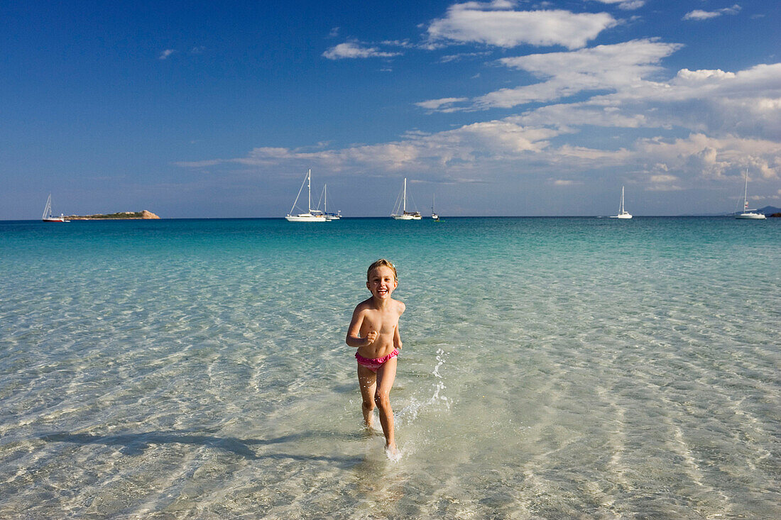 Child running in water, Costa Rei, Sardinia, Italy