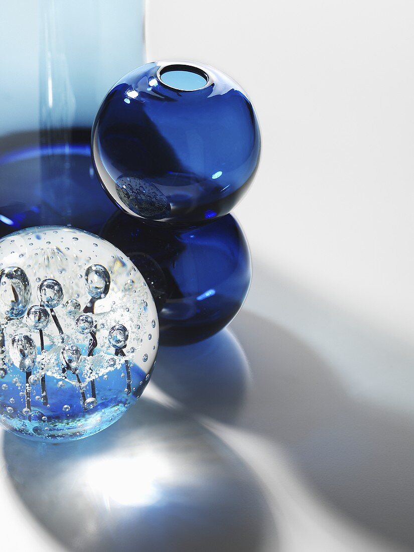 An arrangement of various round blue glass containers