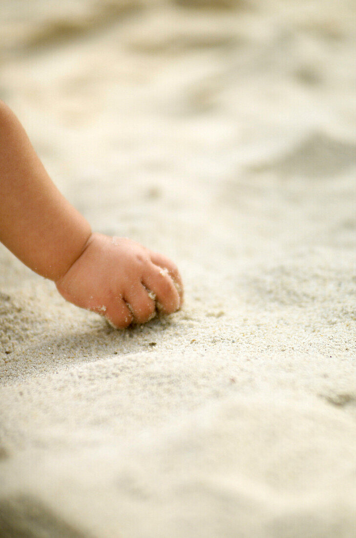 Child's hand playing with sand