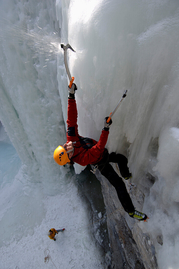Male ice climber ascending ice, British Columbia, Canada
