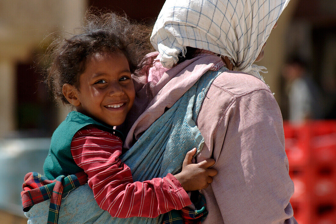 Girl carried by mother, Place el Hedim, Meknes, Morocco