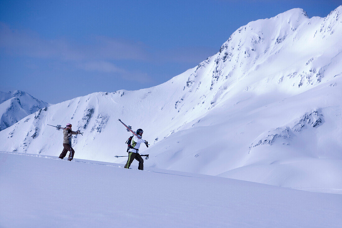 Two skier walking through snow, mountains in the background, Kuehtai, Tyrol, Austria