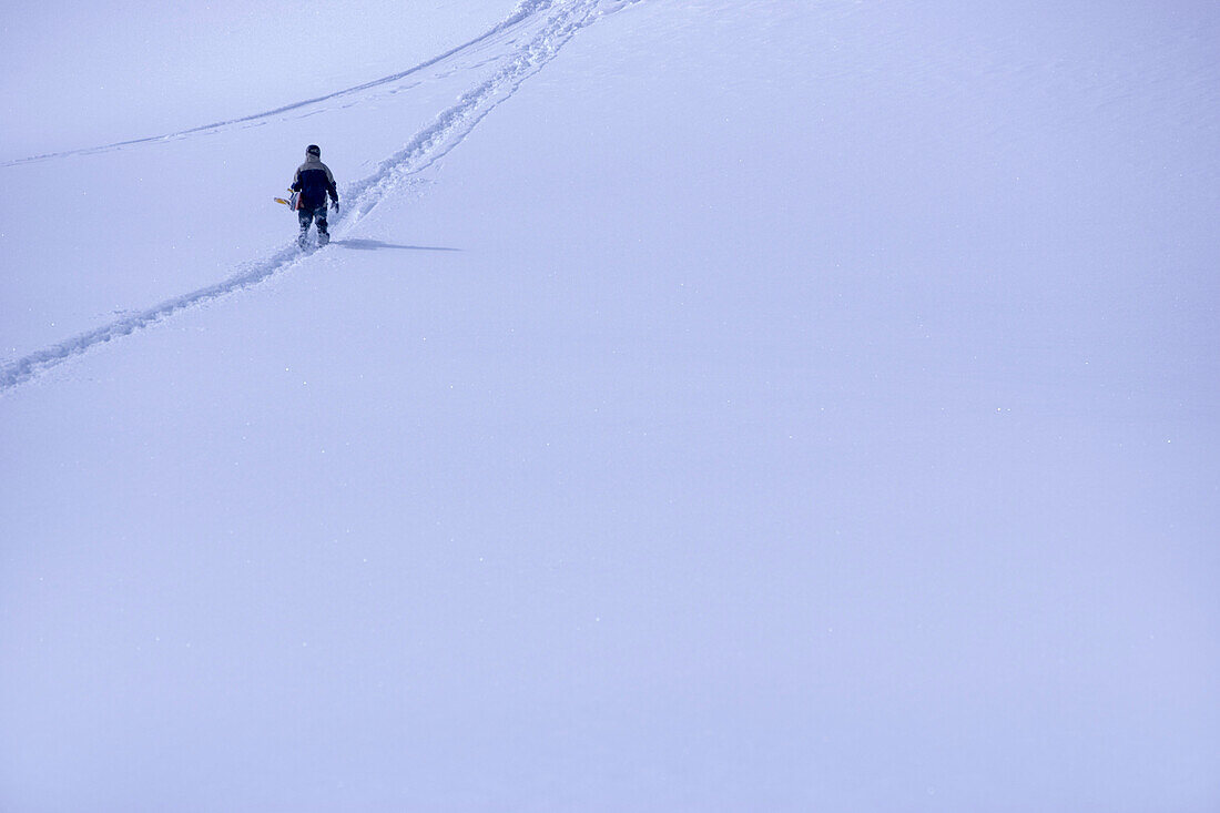 Snowboarder läuft durch den Schnee, Kühtai, Tirol, Österreich