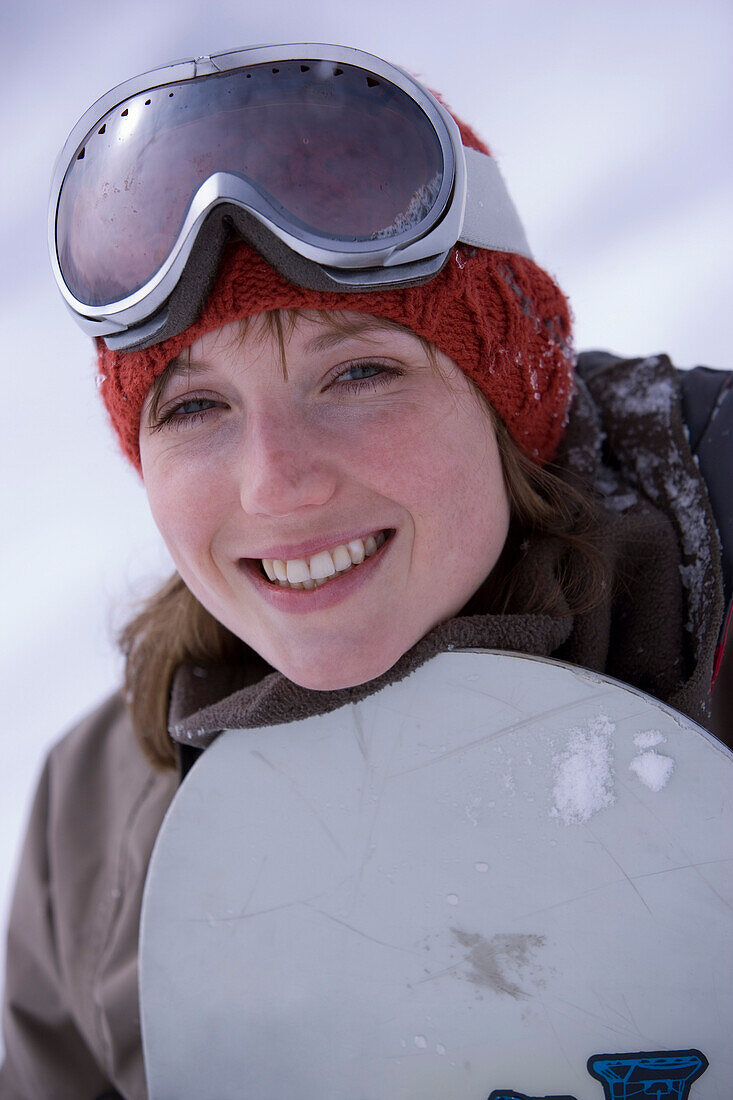 Laughing young woman with snowboard, Kuehtai, Tyrol, Austria