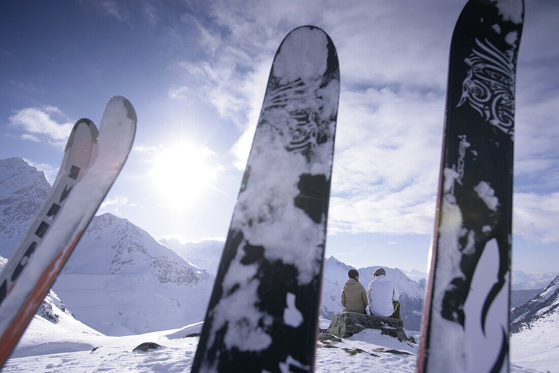 Junges Paar im Schnee neben der Skipiste betrachtet das Bergpanorama, Kühtai, Tirol, Österreich