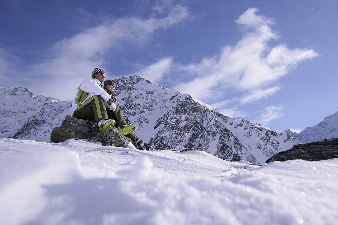 Young couple sitting near slope, looking at view, Kuehtai, Tyrol, Austria