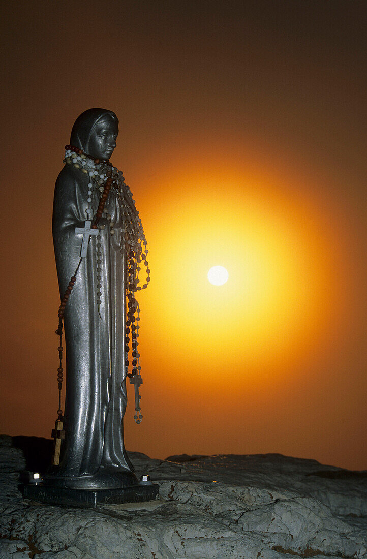 Madonna mit Rosenkranz im Gegenlicht der aufgehenden Sonne, Piz Boe, Sellagruppe, Dolomiten, Südtirol, Italien