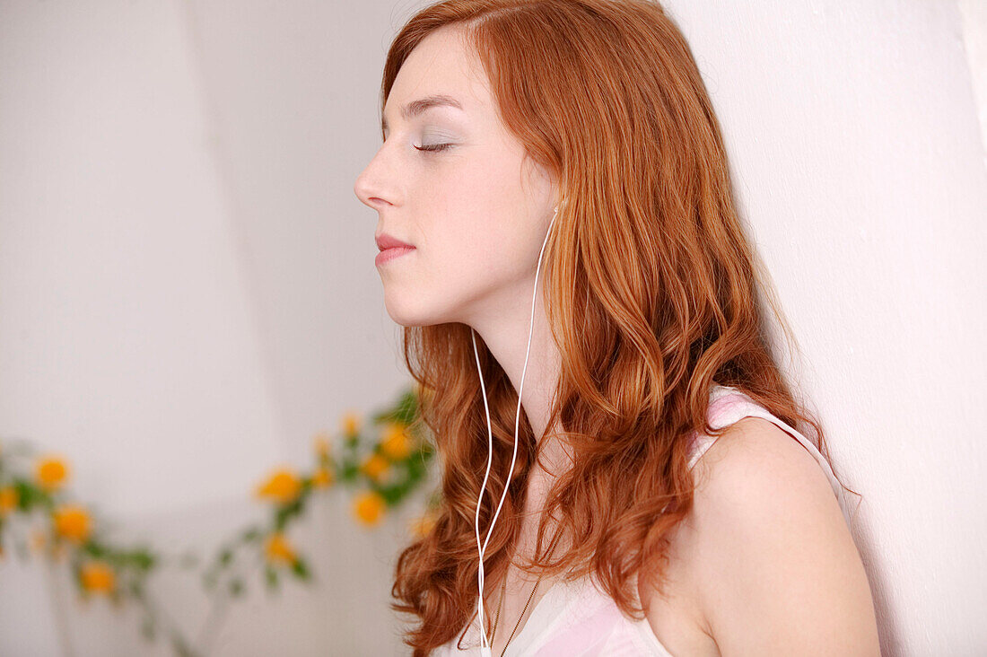 Young woman listening to portable MP3 player