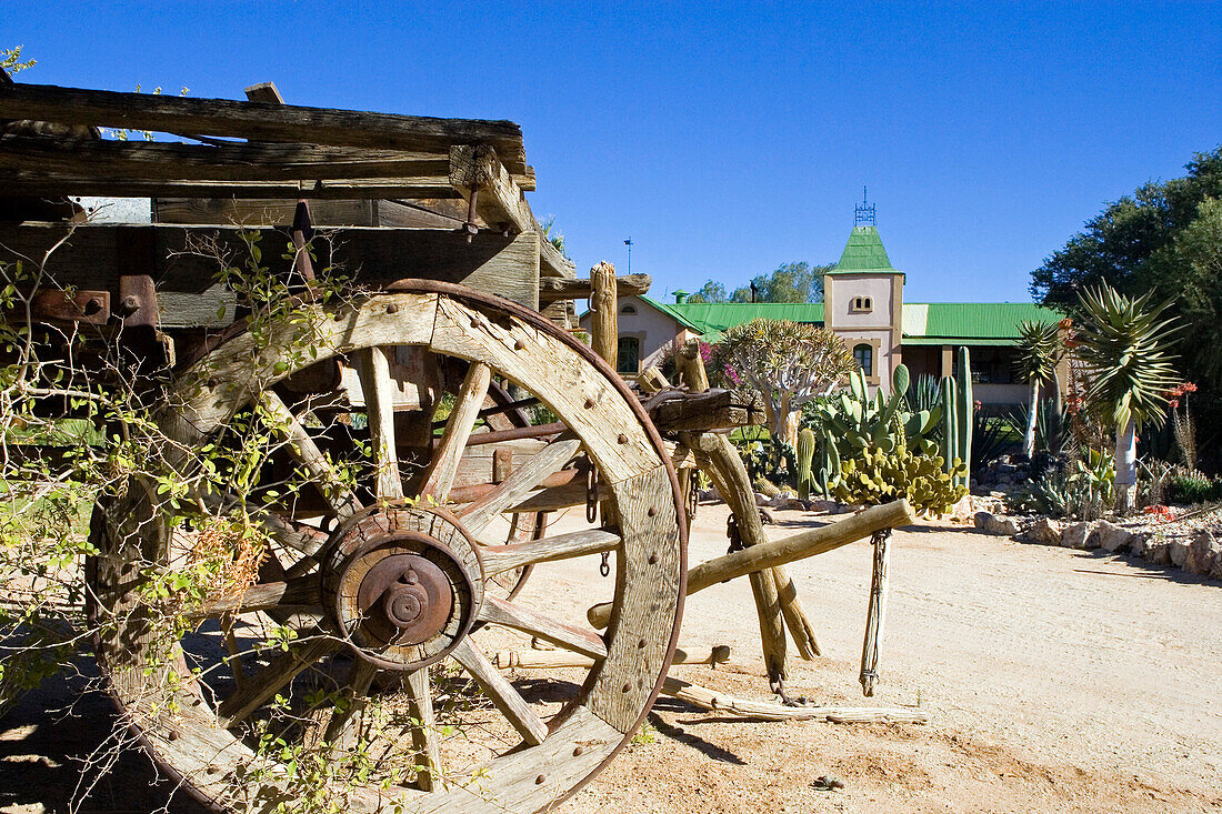 Old wagon, wheel and main building of Canon Lodge, Gondwana Canon Park, Fish river canyon. Southern Namibia. Africa.