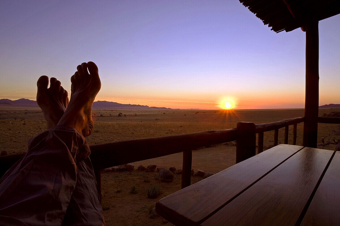 Blosse Füsse vor Sonnenuntergang. Aussicht von der Veranda eines Bungalows Eagles Nest von Klein-Aus-Vista. Gondwana Sperrgebiet Rand Park. Sukkulenten Karoo Wüste. Südliches Namibia. Afrika.
