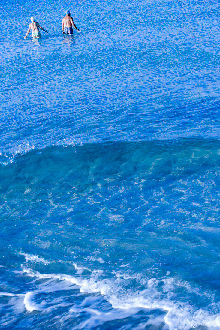 Senior couple go swimming in sea, Apulia, Italy