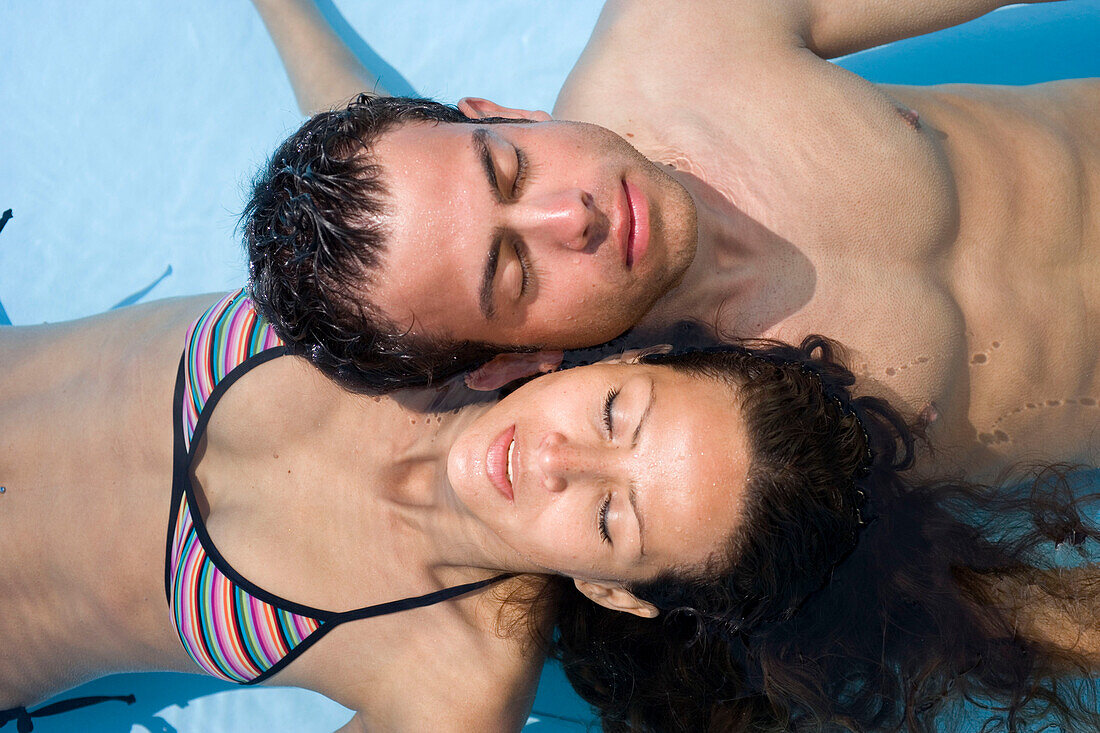 Junges Paar liegt im Swimming pool, Apulien, Italien