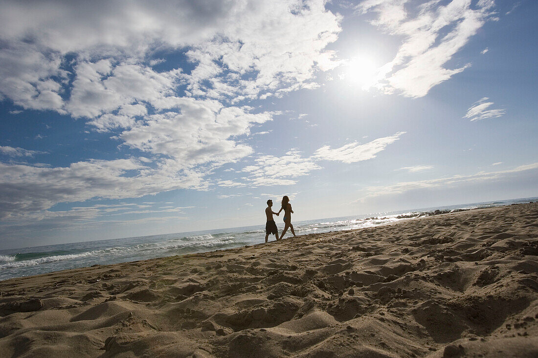 Couple walking on beach, Apulia, Italy