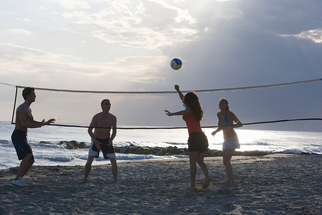 Young people playing beach volleyball, Apulia, Italy