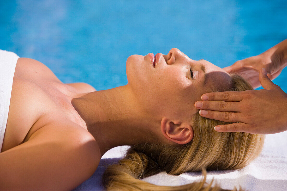 Frau erhält Kopfmassage am Pool, Apulien, Italien