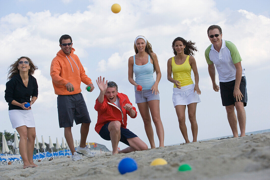 Group of people playing bocce ball on beach, Apulia, Italy