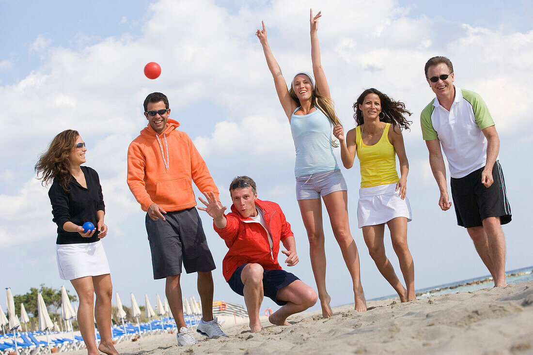 Group of people playing bocce ball on beach, Apulia, Italy