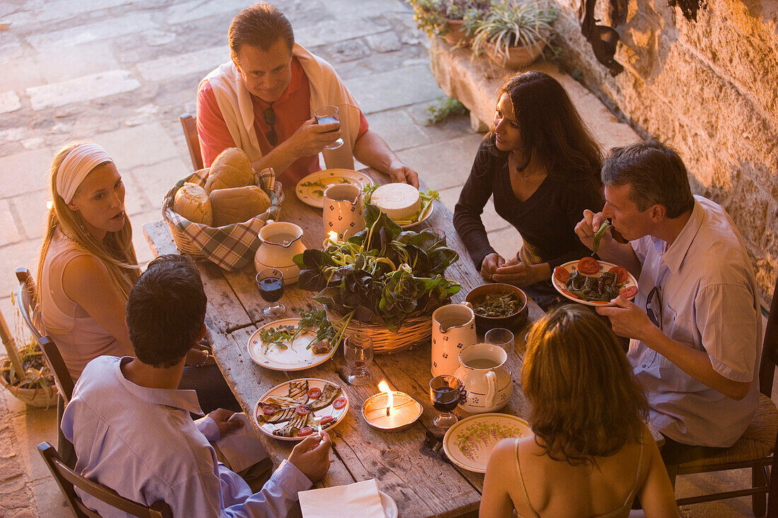 Group of people having dinner together on terrace, Apulia, Italy
