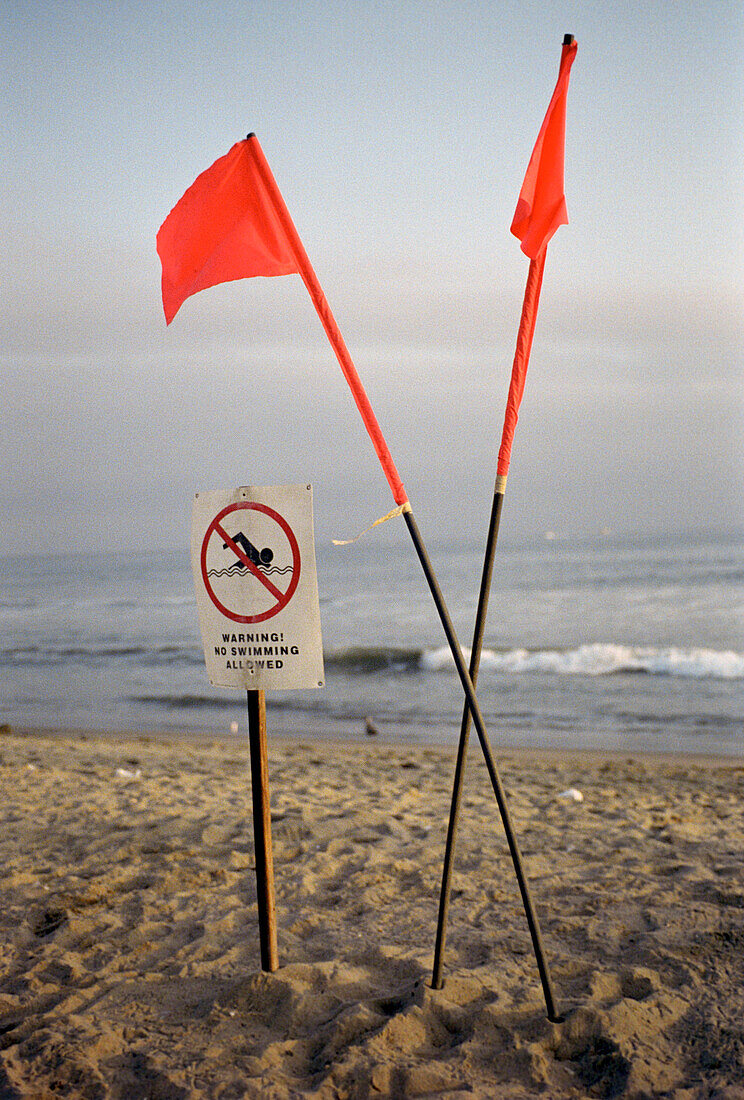Rote Fahnen und ein Schild am Venice Beach, Los Angeles, Kalifornien, USA