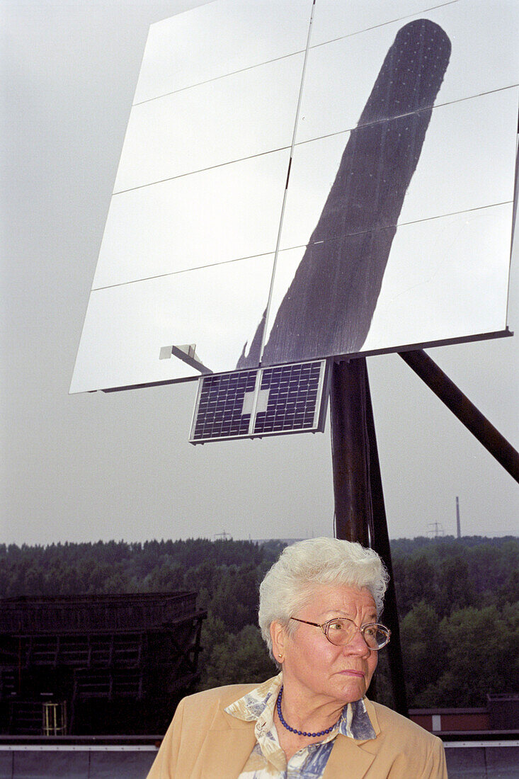 Old woman in front of solar plant, Zeche Zollverein, Essen, North Rhine-Westphalia, Germany, Europe